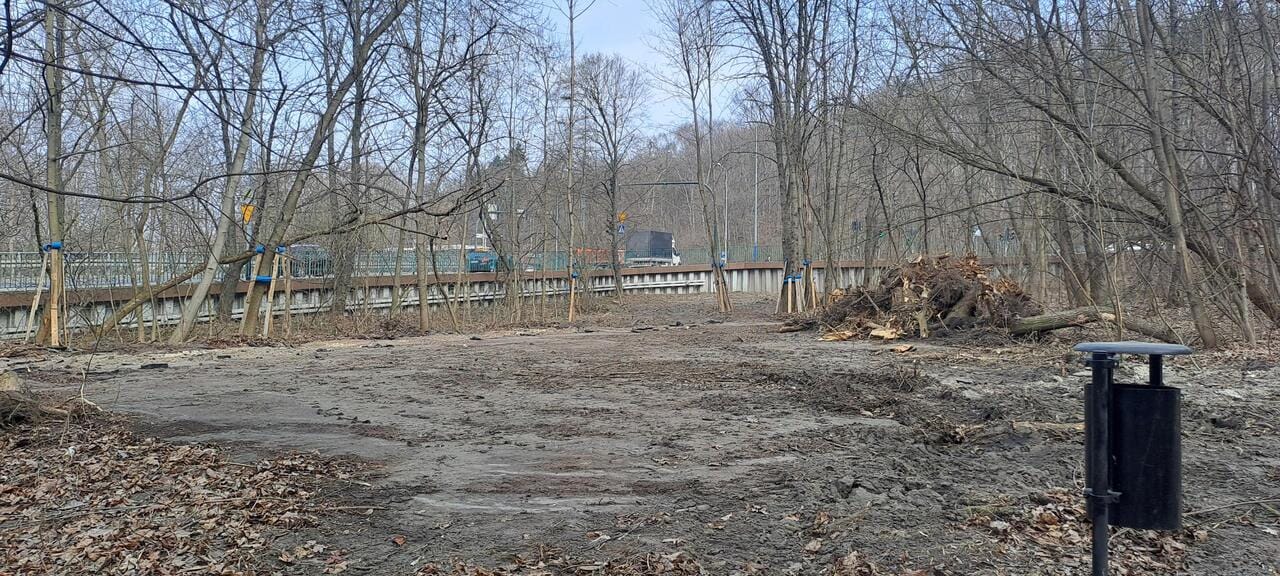 Widok na miejsce planowanej trasy pieszo rowerowej w Parku Bonarka. W tle widoczna ulica Kamieńskiego w Krakowie